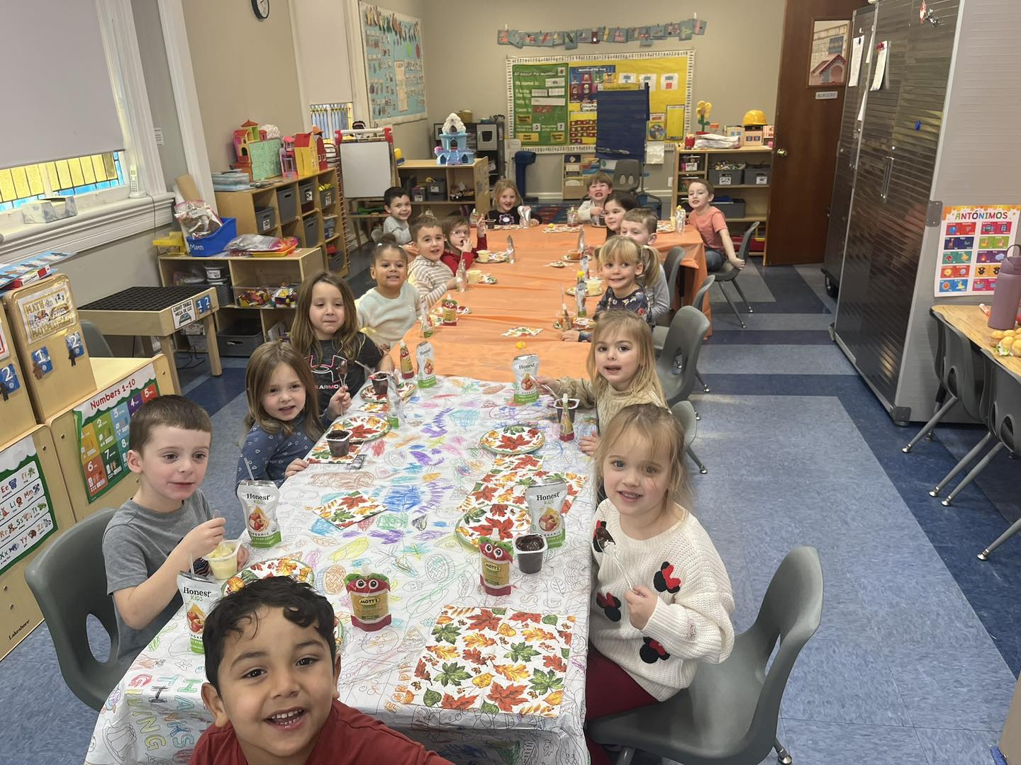 Large group of kids sitting at a long table.