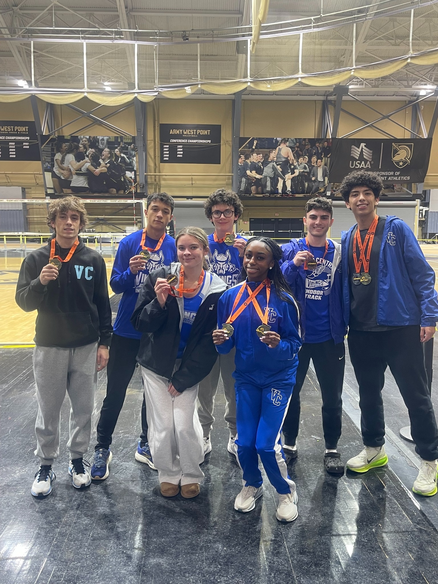 Indoor Track team posing wearing medals.