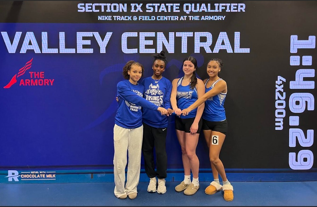 Four valley central girls standing in front of a backdrop that says Valley Central 1:46:29.