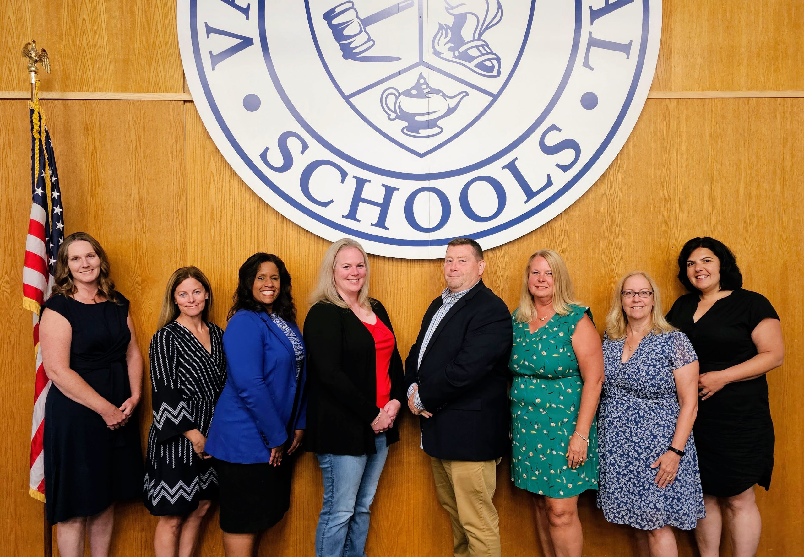 2023-2024 Board members with flag: Jane Samuelson, Sarah Messing, Superintendent Evette Avila, VP Katie McKnight, Pres. Joseph Bond, Diana Revoir, Fran Fox-Pizzonia, Angela Terralavoro