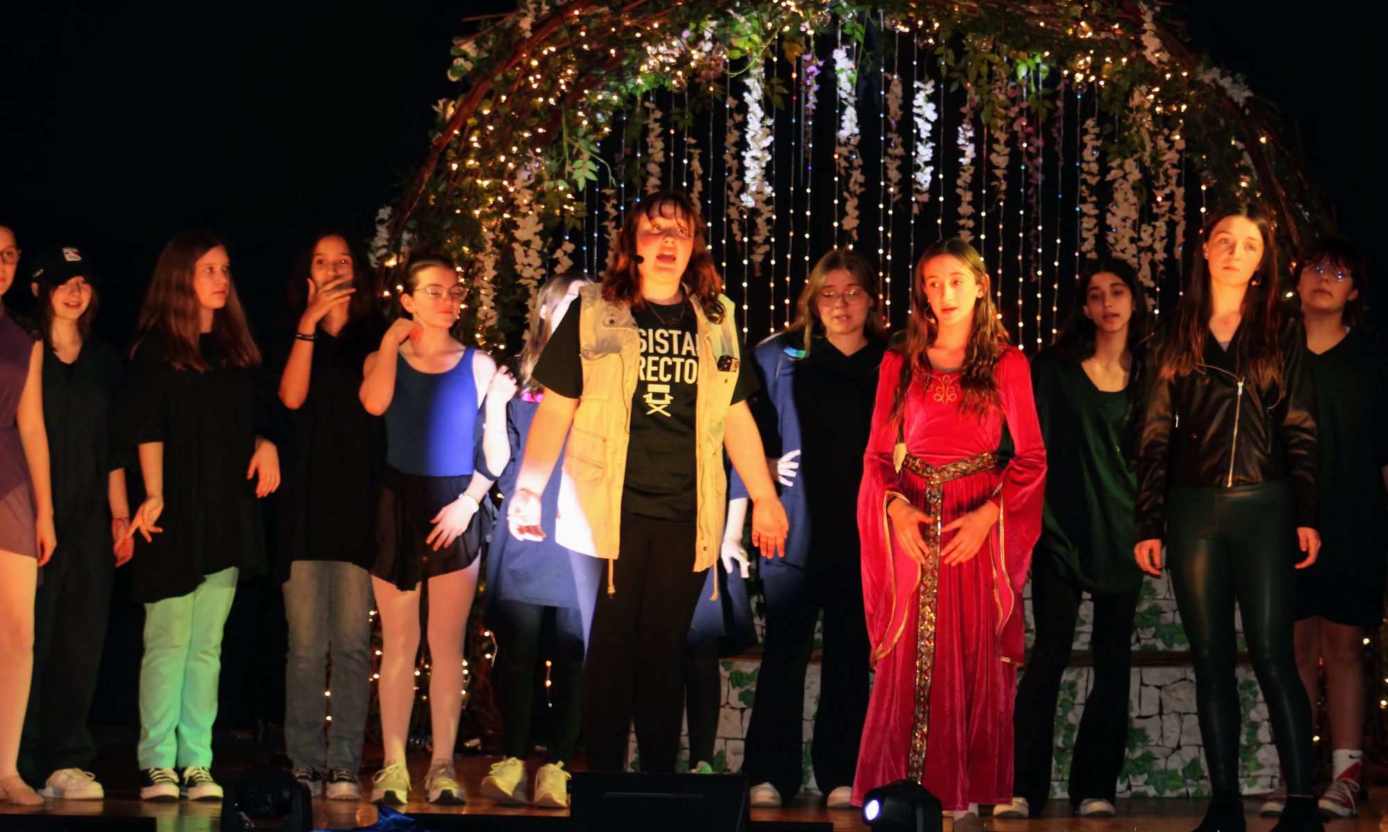 VCMS Students perform their musical revue, "All the World's a Stage" on November 16. One student is center singing surrounded by other students on the stage.