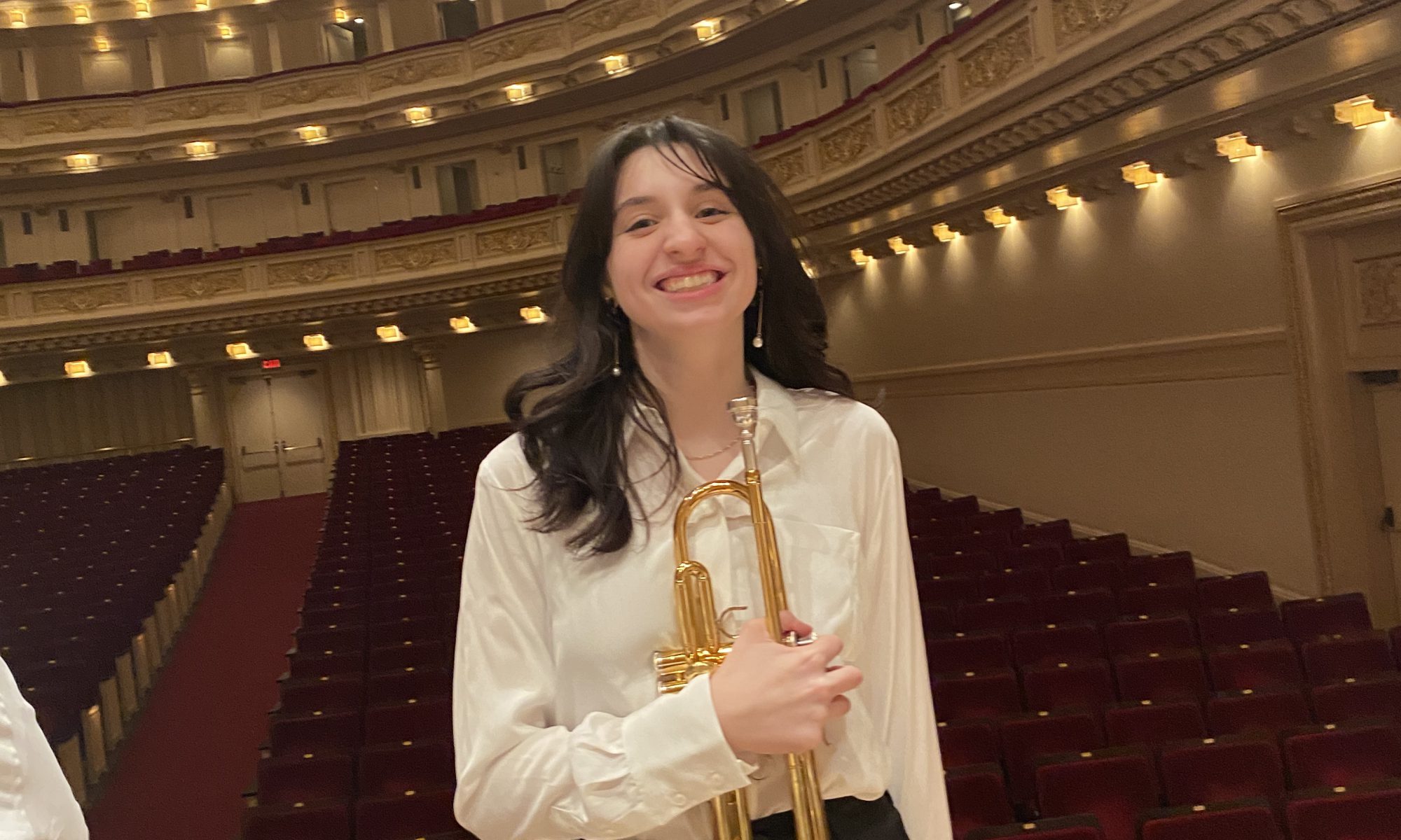 VCHS Junior, Amelia, is shown on stage at Carnegie Hall with her trumpet where she was selected to participate in the The Honors Performance Series by WorldStrides.