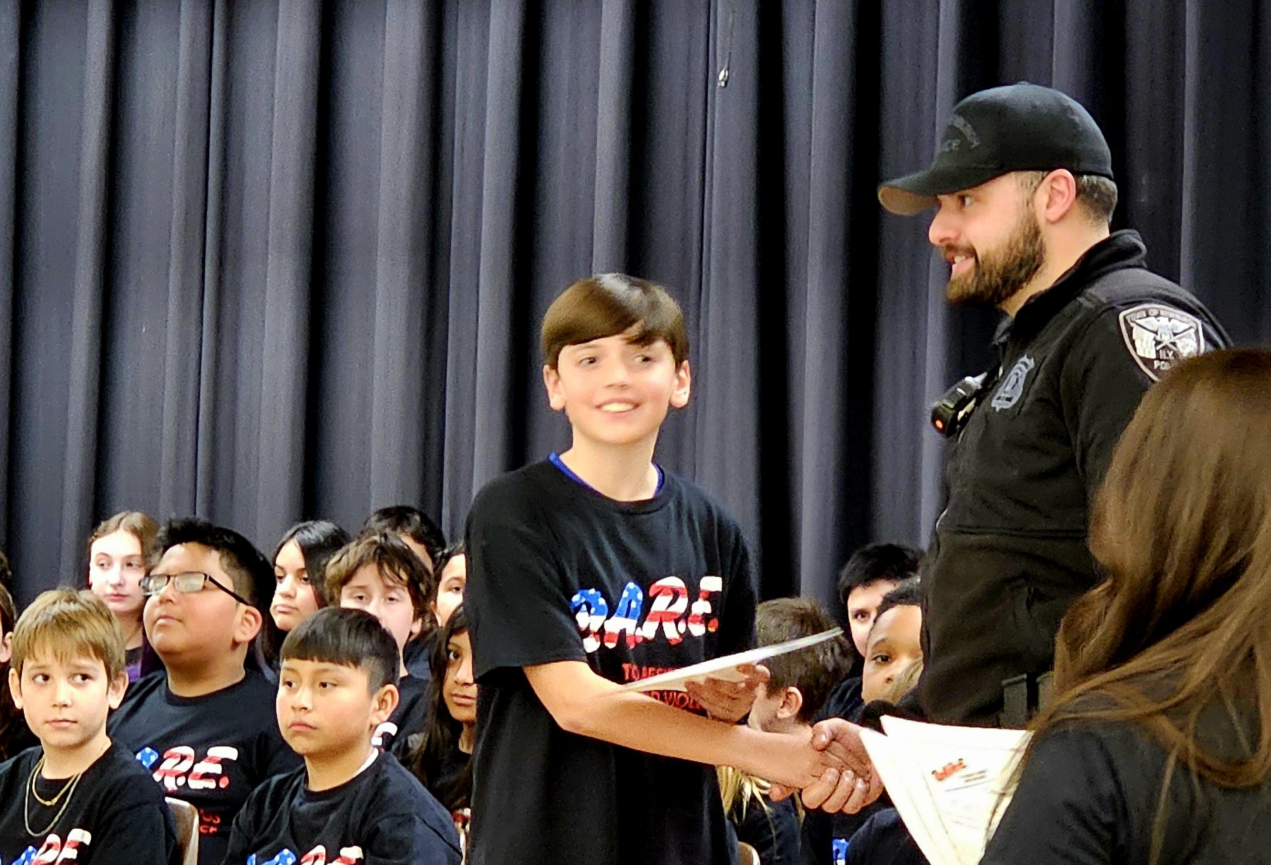 An EC Student receives his certificate from the DARE officer