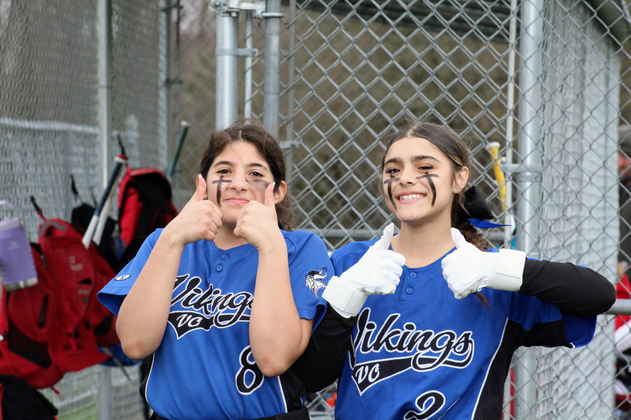 Two softball team members give a thumbs up before they are up to bat! 