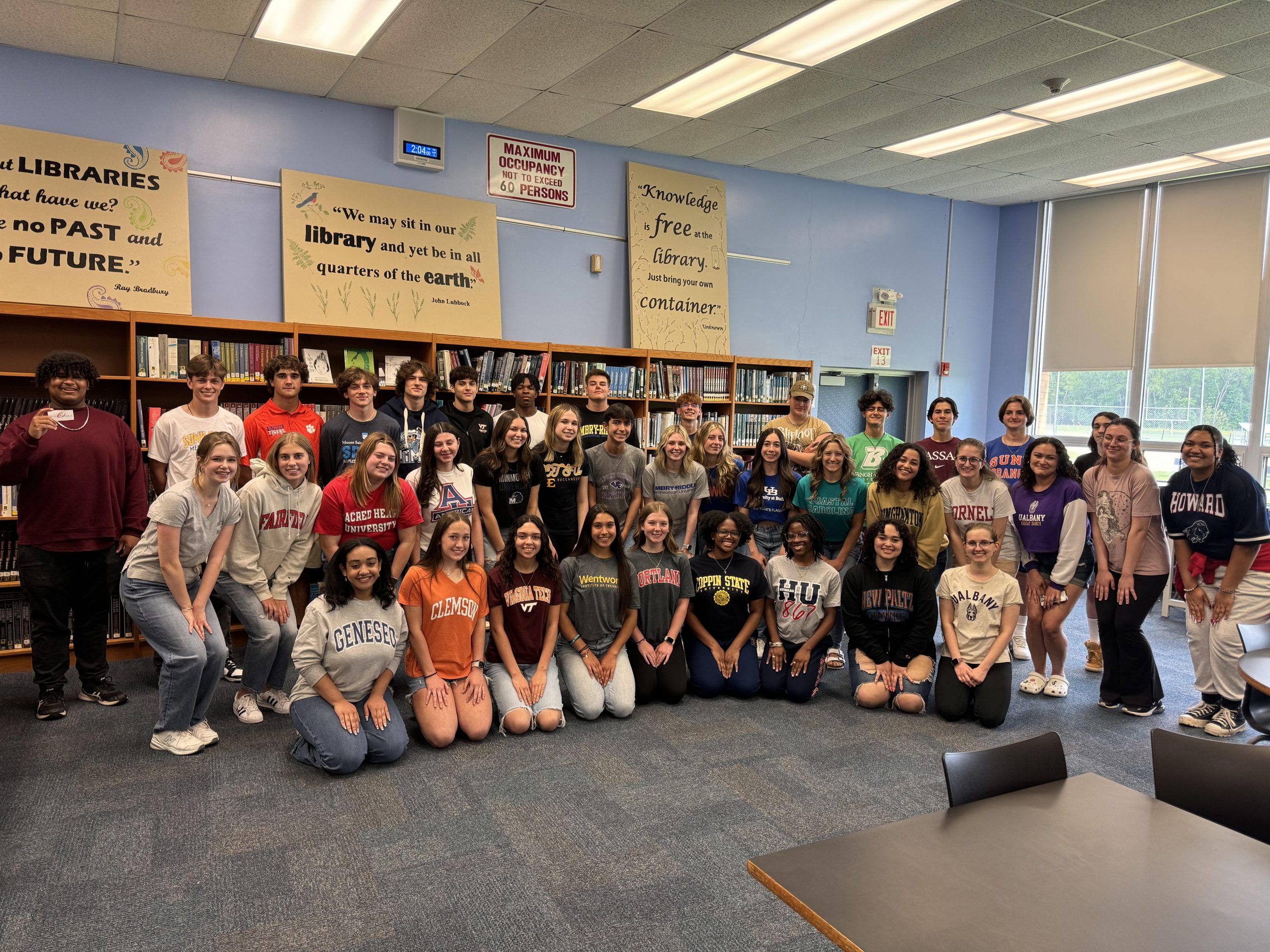 About 40 HS seniors pose for a group photo for Destination Day wearing tee-shirts from their stop after high school. Their tee-shirts represent the colleges ,universities and trade schools that they will be attending. The photo was taken in the HS library.