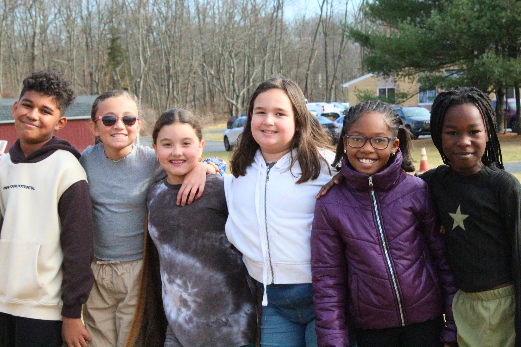 Six students are smiling at the camera and standing near each other. 