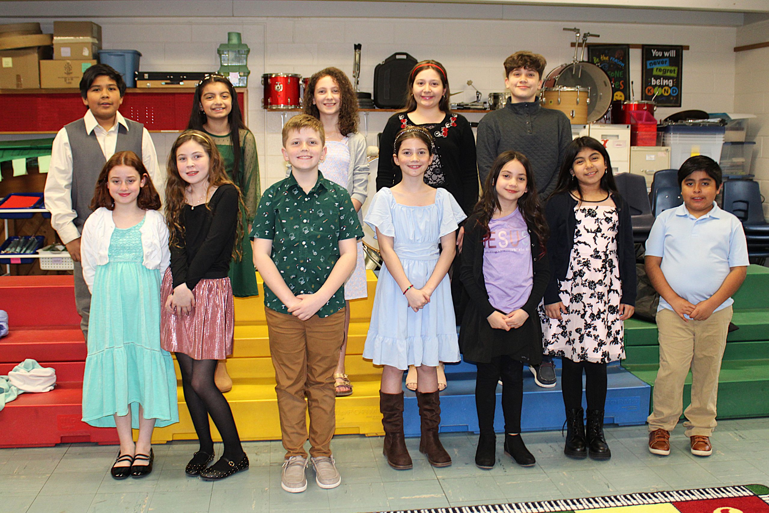 Students stand together in the music room and smile for a photo. 