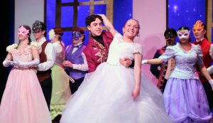Cinderella is dancing with actors around her. 