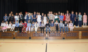Students at Montgomery elementary school smile for a photo on stage with their recognition. 
