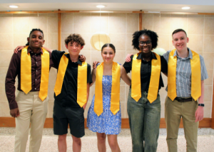 Five students with yellow stoles on for the national junior honor society induction. 