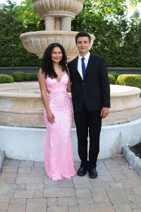Two students stand at the senior ball in a dress and a suit. 