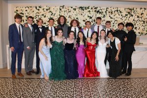 A group photo of students that are attending the senior ball are looking at the camera and smiling. 