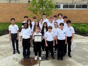 A group of students stands and smiles at the camera. 