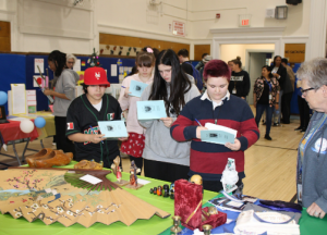 Students look at a piece of paper as they record their answers at the cultural fair. 