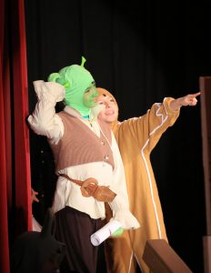 Two students are on stage acting during Shrek