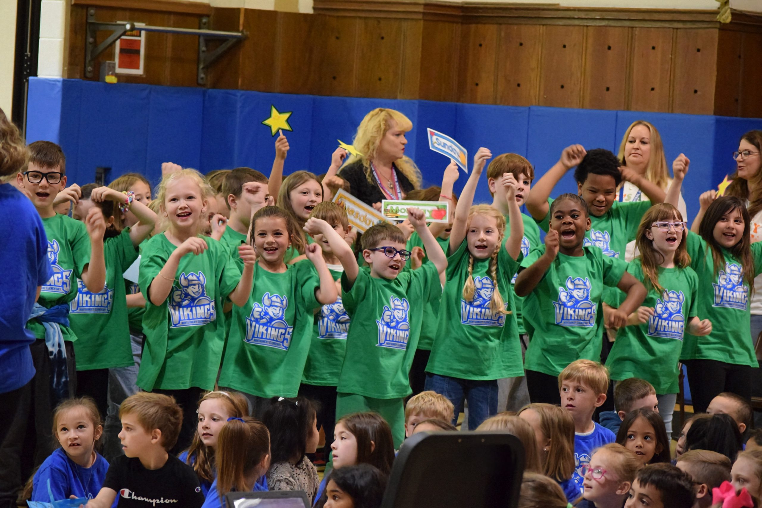 Students stand and smile in green Valley Central shirts in Montgomery Elementary School