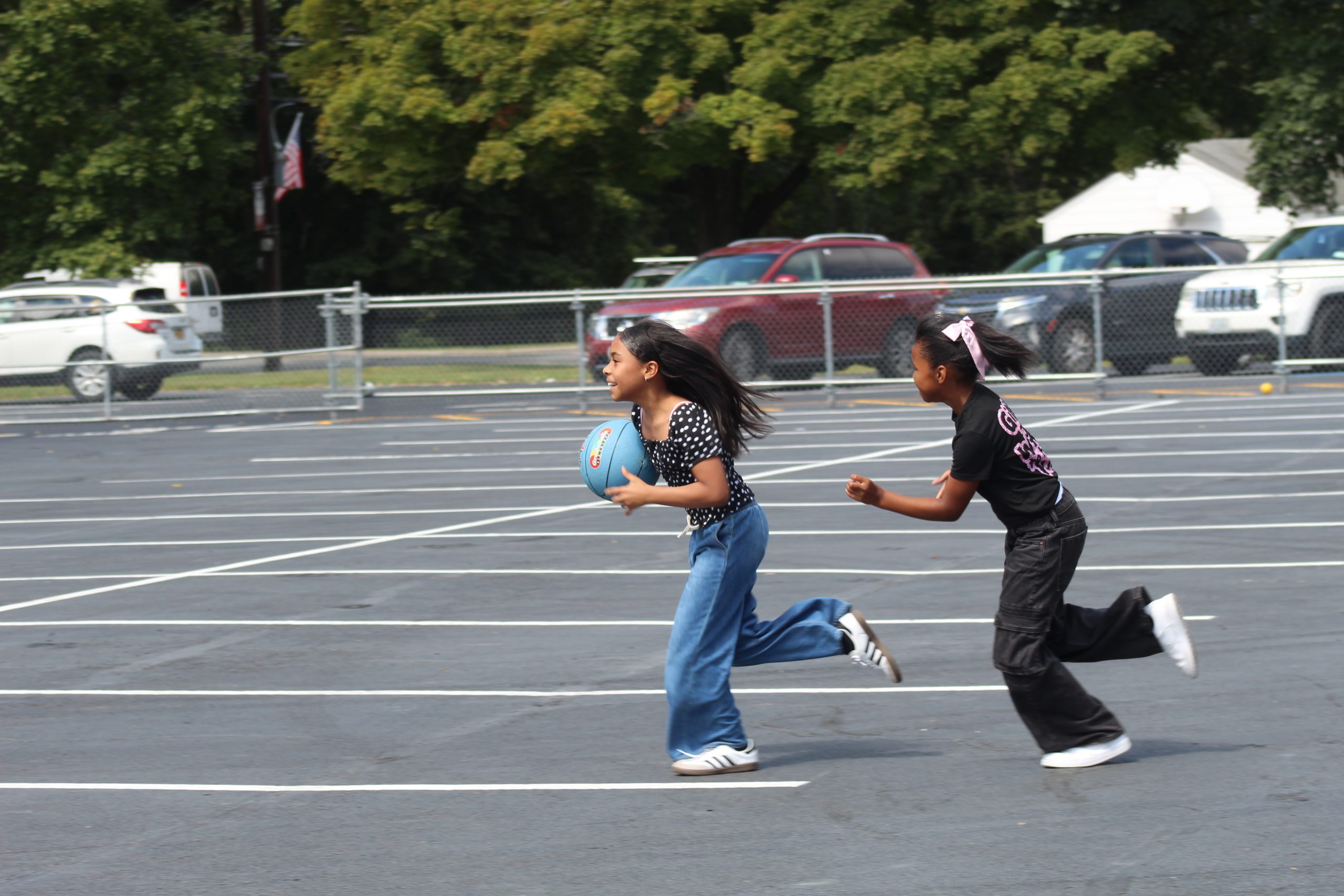 Two girls run on the playground on the first day of school. 