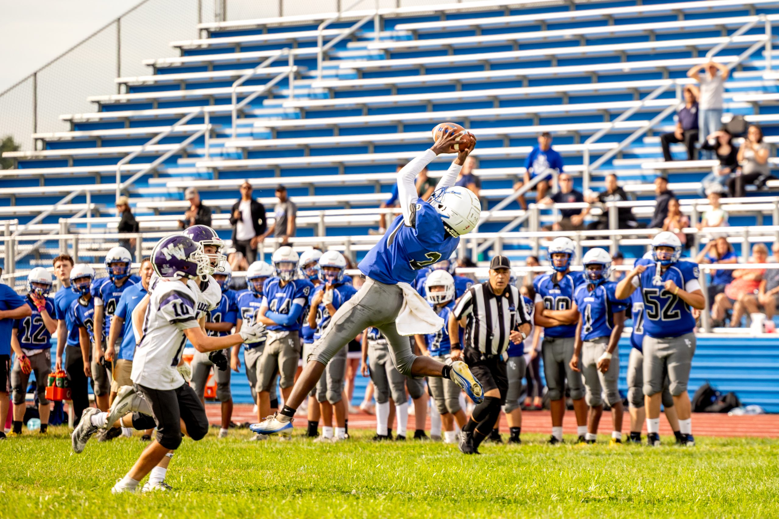 JV Football Player making a catch mid air.