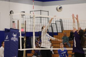 VC volleyball player hitting the ball over the net.