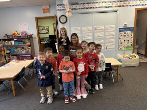 Group of pre-k students and a teacher in a classroom.