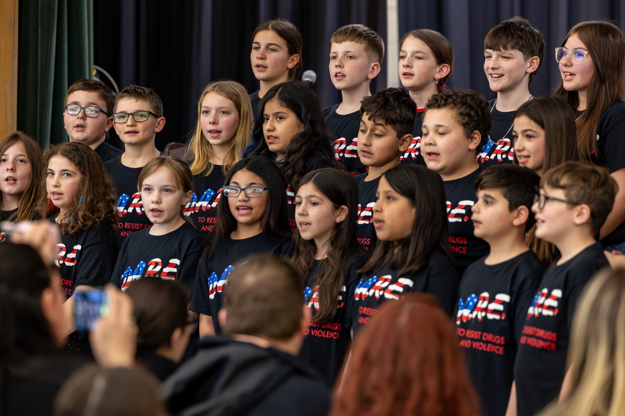 Large group of kids wearing DARE shirts at DARE graduation.