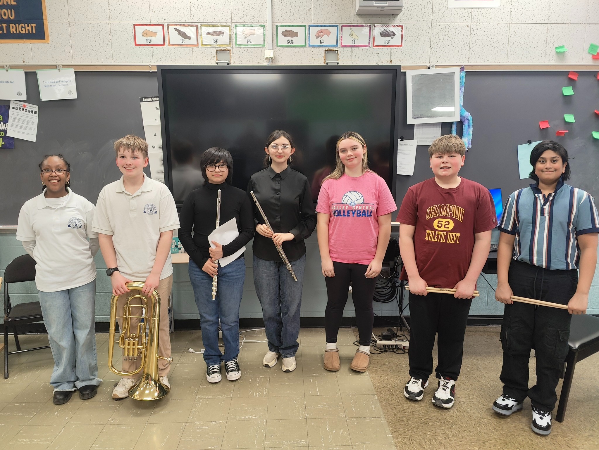 Seven students posing holding their band instruments.