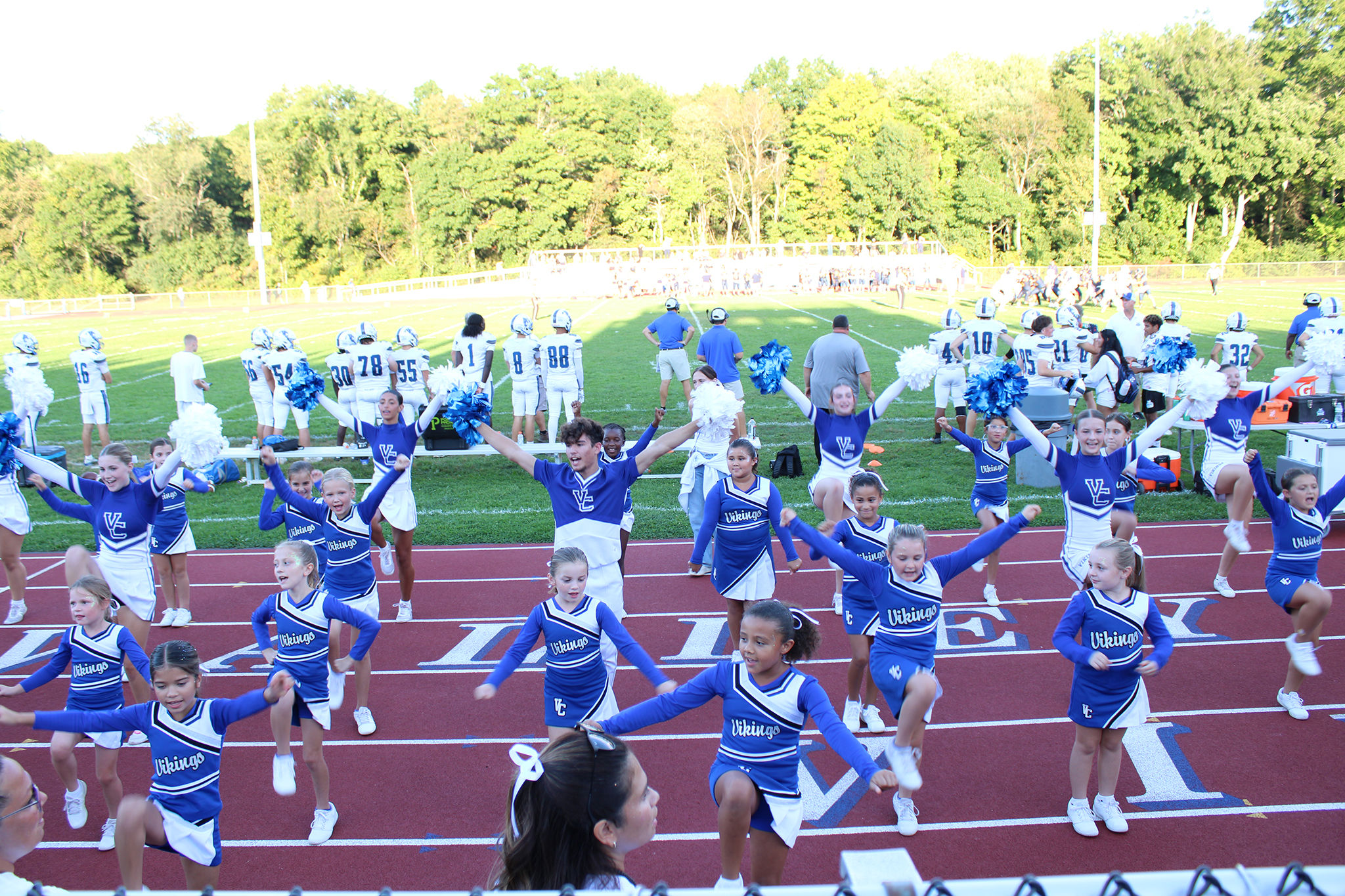 High school and youth cheerleaders performing during a football game